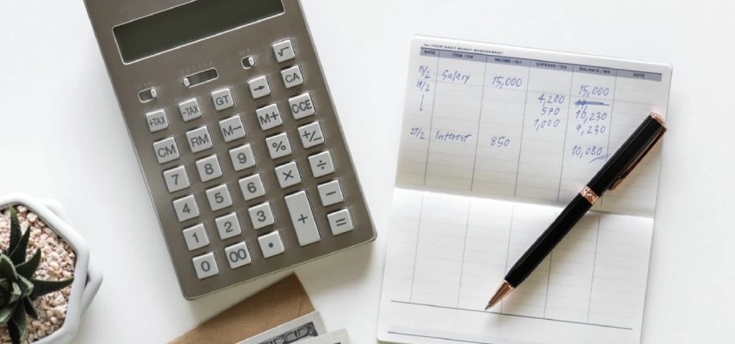 Calculatrice posée à côté d'un carnet de notes